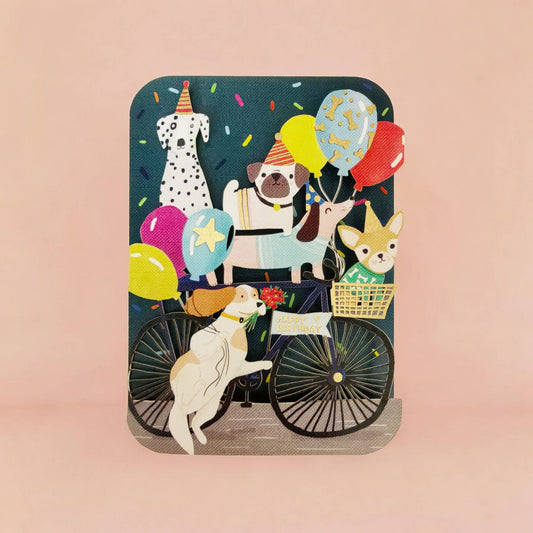 Tarjeta de cumpleaños con perros alegres en paseo en bicicleta